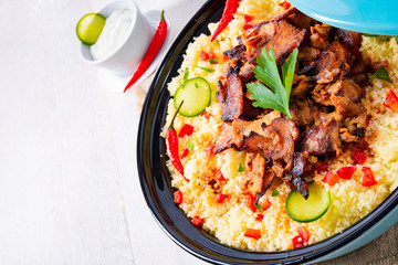Tajin with couscous, vegetables and meat on white background