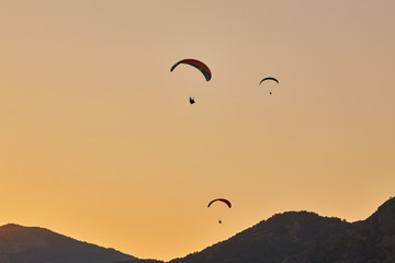 Naklejka na ściany i meble Silhouette Of Paragliders Against Dramatic Sky