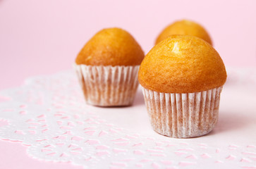 The tasty muffins on pink background. Cup cake on napkin