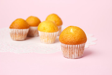 The tasty muffins on pink background. Cup cake on napkin