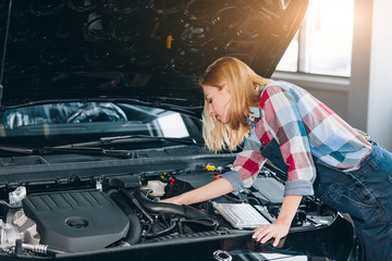 pretty awesome girl checking her car. close up photo, professional mechanic is good at fixing vehicles