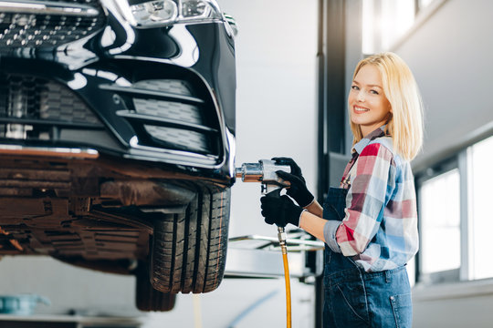 positive awesome girl holding impact wrench and looking at the camera. close up photo.pastime concept