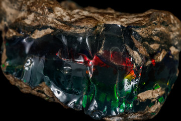 Macro stone Opal mineral in rock on a black background close up