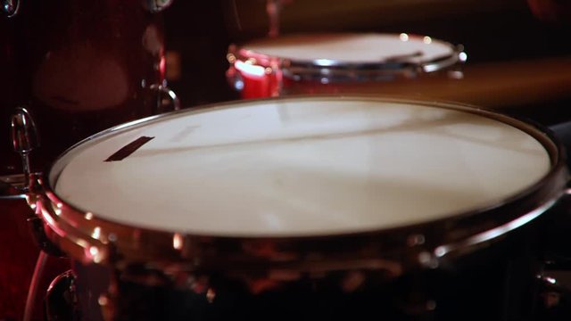 drummer, jazz lesson , standart drumsticks , drumroll on a snare  a rehearsal studio on a red drums , low key, close-up