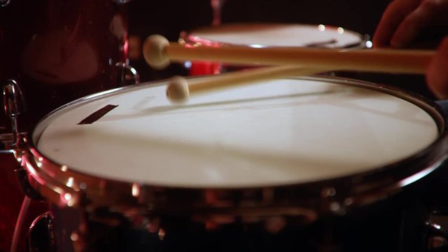 drummer, jazz lesson , percussion drumsticks , drumroll on a snare  a rehearsal studio on a red drums , low key, close-up