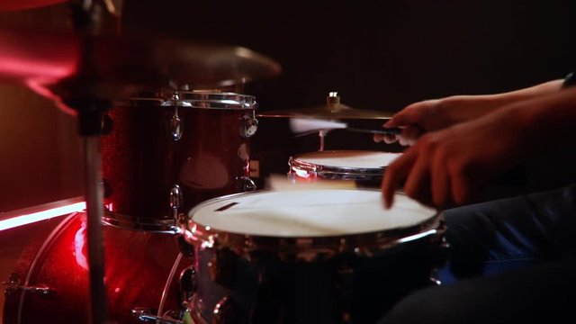  drummer, jazz lesson swing, classic grip of brushes drumsticks on a snare a rehearsal studio on red drums , low key, red light.