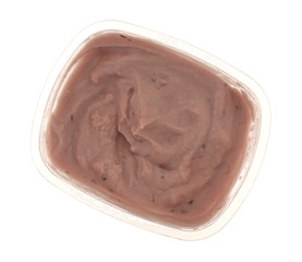 Small container of red raspberry yogurt on a white background top view