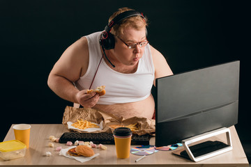 Fototapeta na wymiar obese guy chatting online with friends isolated over black background. close up portrait. internet , conversation concepts