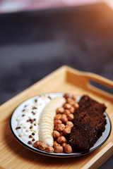 Healthy breakfast with delicious bread, banana, hazelnut and yogurt in bowl