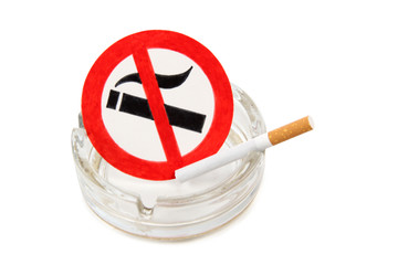 Glass ashtray and cigarette on white background