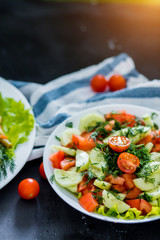 Fresh spring vegetable salad on a black background, close-up