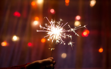 Person hold a sparkler stick in a hand. Festival sparklers. Happy New year. 