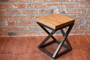 stylish stool against a red brick wall