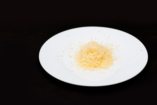 Shredded Grated Cheese On Black Background, Close Up