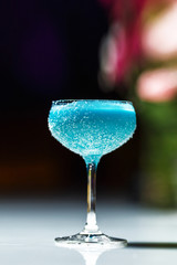 Alcoholic cocktail in a glass goblet on the bar counter.