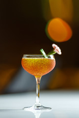 Alcoholic cocktail in a glass goblet on the bar counter.