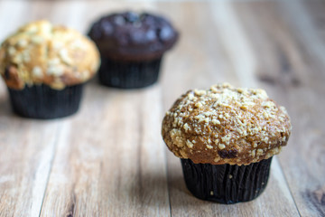 Assorted muffin on wooden background.