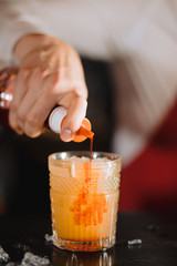 Bartender pours syrup in exotic fruit cocktail, Exotic fruit cocktail in glass isolated on blurred...