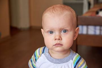 Portrait of a little thoughtful boy with blue eyes