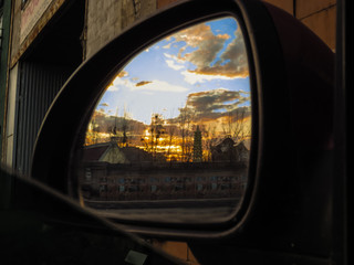 Fototapeta na wymiar The reflection of a beautiful sunset in the rearview mirror