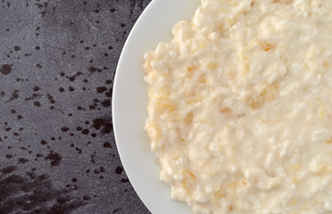 Top close view of pineapple cottage cheese on a white plate atop a gray table