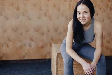 young girl in sportswear in a gym in a simple background, a theme of fitness, a crossfit and sport