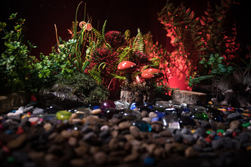 Fantasy glowing mushrooms in mystery dark forest close-up. Beautiful macro shot of magic mushroom or souls lost in avatar forest. Fairy lights on background with fog.