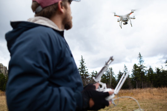 Male tourist exploring new places. Handsome bearded man on nature with fuel. Using drone photographs and shoots nature