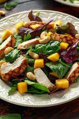 Grilled Chicken Mango salad with nuts and vegetables. Healthy food.