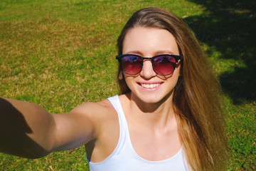 Portrait of young beautiful woman in tropical destination park with greenery on the background. Joy of summer holidays concept. Close up, copy space.