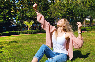 Obraz premium Portrait of young beautiful woman in tropical destination park with greenery on the background. Joy of summer holidays concept. Close up, copy space.