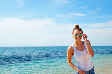 Portrait of young beautiful woman in tropical destination island beach with the ocean background. Joy of summer holidays concept. Close up, copy space