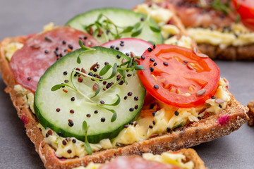Sandwiches with cream cheese, vegetables and salami.