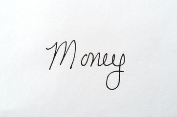 The word money written on a white piece of paper.