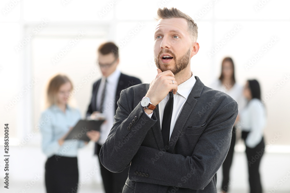 Wall mural portrait of a dreaming businessman on a blurred office background