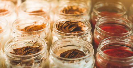 Many delicious desserts in a jar on the window of a cozy cafe. Tasty sweets