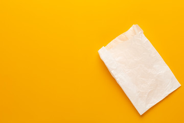 White paper bag on yellow background.
