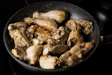 frying pan with juicy fried chicken
