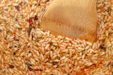 Mexican rice and beans mix in a skillet with a wood spoon in the food