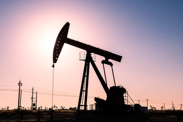 Oil pumps are running in the sunset at the oil field. On the Bohai coast of China.