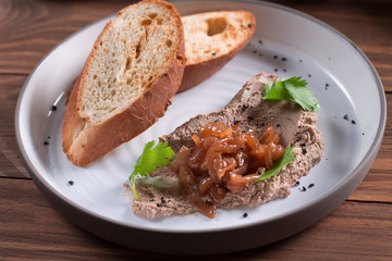 Fresh homemade chicken liver pate on bread over rustic background