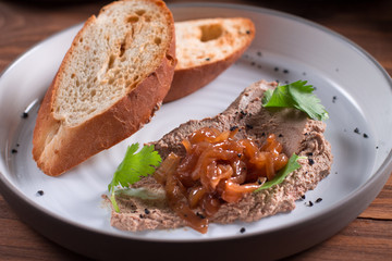 Fresh homemade chicken liver pate on bread over rustic background