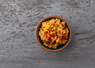 Top view of a small bowl of Mexican rice and beans on a gray background