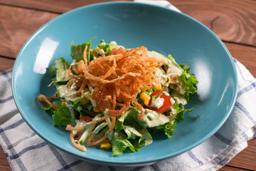 Mexican salad with tomatoes, mixed greens, fried onions