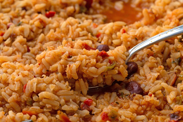 Cooked Mexican rice and beans in a skillet with a heaping spoonful on the food