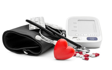 Electronic tonometer with stethoscope, red heart and pills on white. Medical concept.