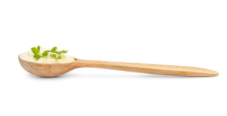 Wooden spoon with grated parmesan on white.
