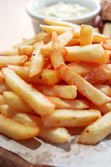 French fries served on wooden board closeup