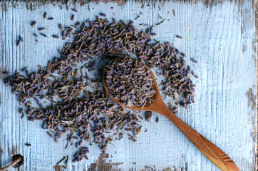 Close-up top view of dry lavender in spoon on a white kitchen board