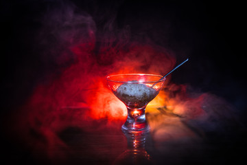 Glass filled with colorful fruit ice cream on dark background with toned light and fog